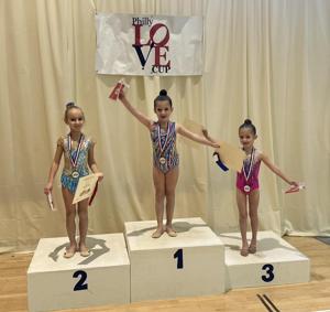 Three Phoenix gymnasts on the winners' podium at the Philly Love Cup