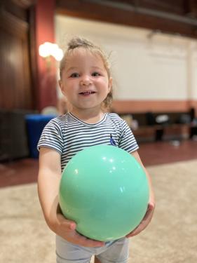 The club's youngest gymnast holding a rhythmic gymnastics ball